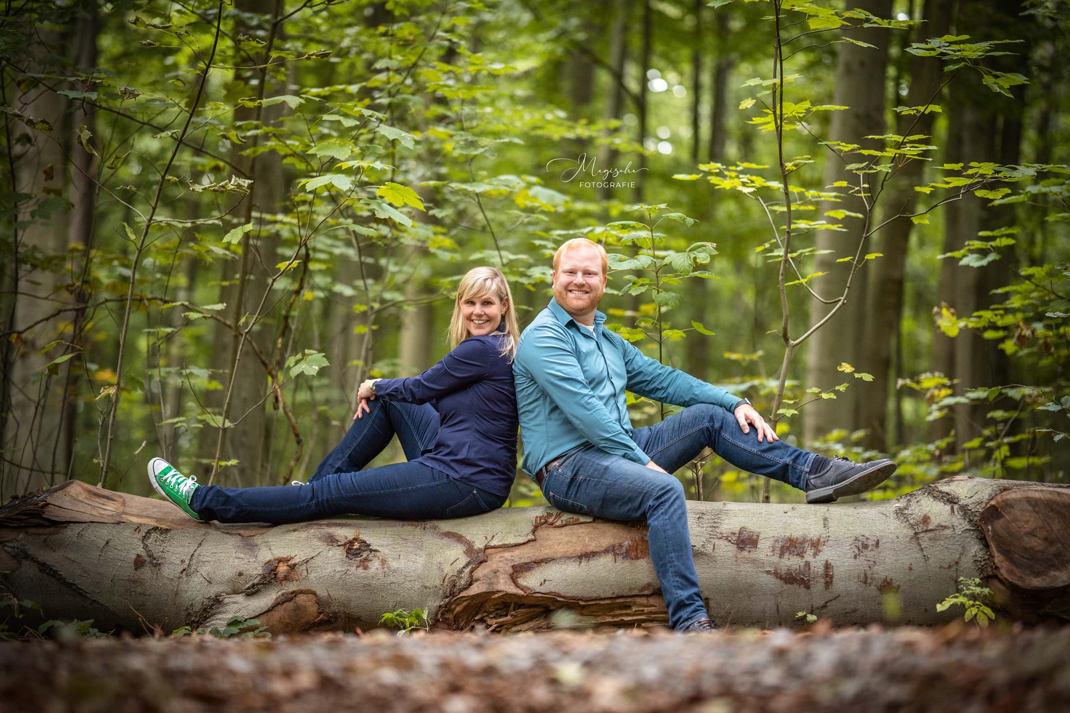 Paar sitzt auf Baumstamm